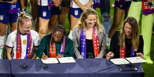 US Soccer Federation president Cindy Parlow Cone and Becky Sauerbrunn, Crystal Dunn, and Sam Mewis of the United States sign the Collective Bargaining Agreement after a game between Nigeria and USWNT at Audi Field on September 6, 2022 in Washington, DC.