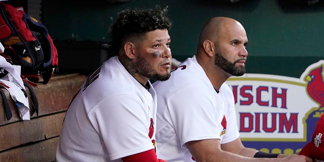 The St. Louis Cardinals' Yadier Molina, left, and Albert Pujols sit together in the dugout during the ninth inning of Game 1 of a National League wild-card series against the Philadelphia Phillies, Friday, Oct. 7, 2022, in St. Louis.