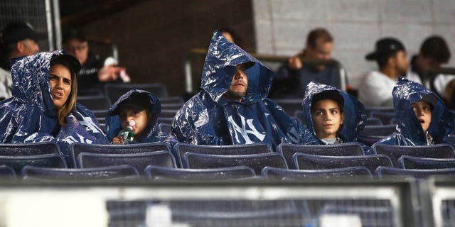 New York Yankees fans look on from the stands during a rain delay prior to playing the Cleveland Guardians in game five of the American League Division Series at Yankee Stadium on October 17, 2022 in New York, New York.