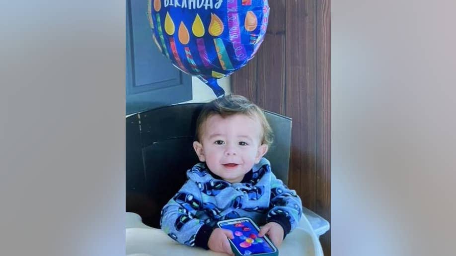 Quinton Simon smiling in front of a balloon