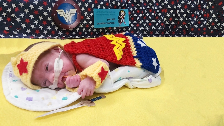 Sleeping baby dressed as Wonder Woman