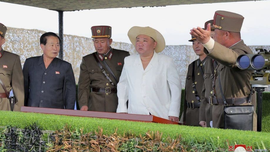Kim Jong Un wears hat and white button down 
