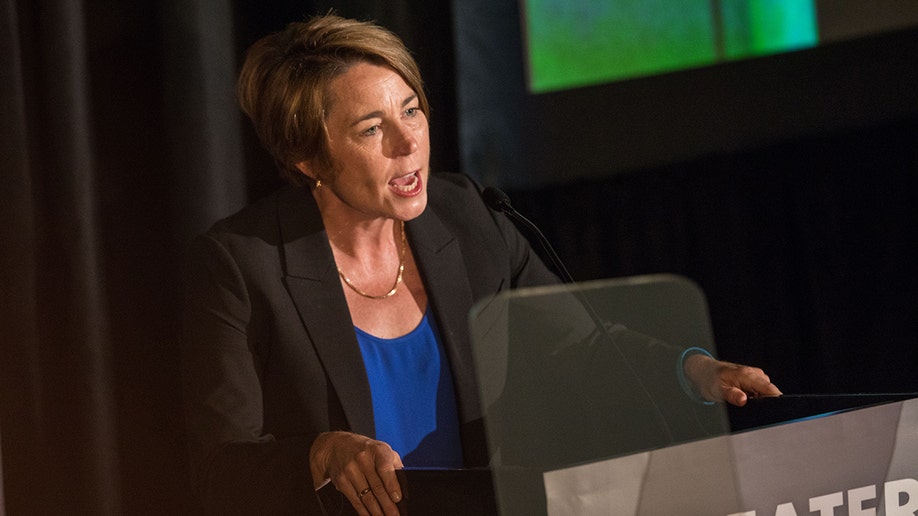 A photo of Maura Healey behind a podium