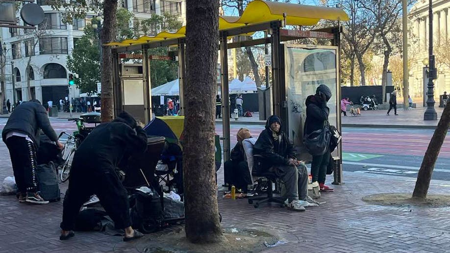 San Francisco bus stop crowded by homeless.