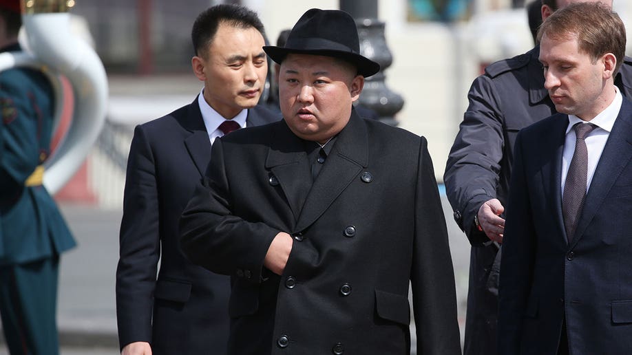 Kim Jong Un wears a black blazer and hat