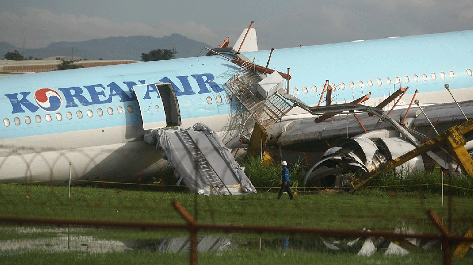 Man inspects damaged aircraft