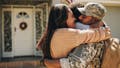 Military serviceman reuniting with his family after deployment. Soldier embracing his wife and daughter after returning from the army. Military man receiving a warm welcome from his family at home.