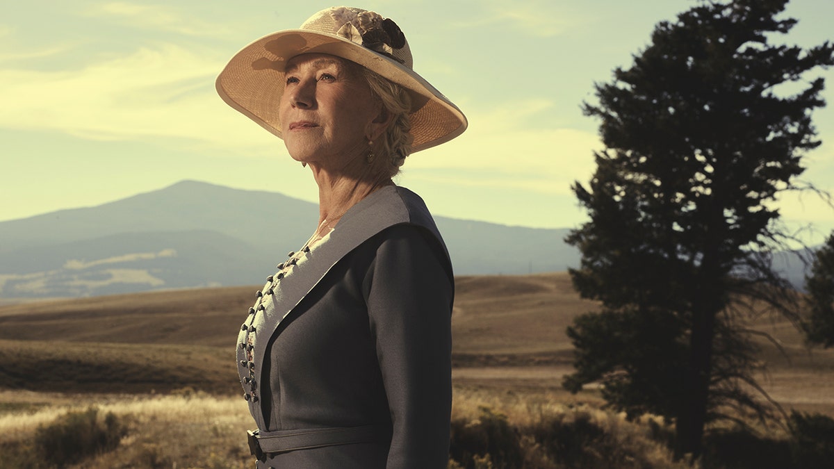 Helen Mirren as Cara Dutton, stares off into the distance with her hat and necklace