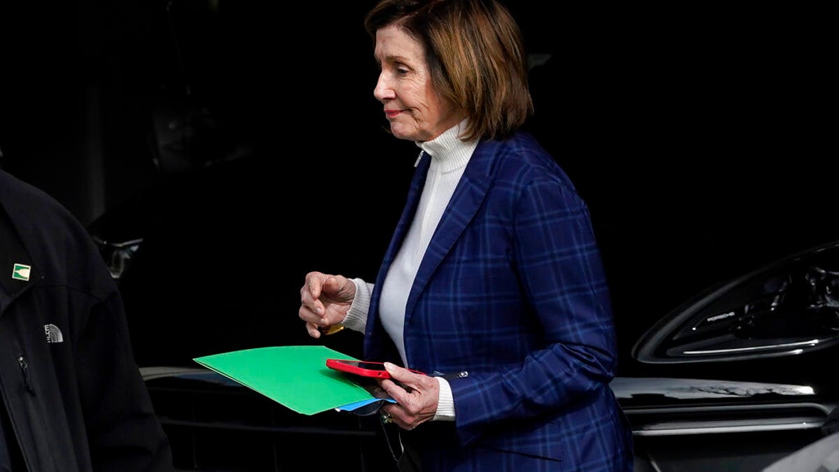 Nancy Pelosi leaves her garage holding green folder