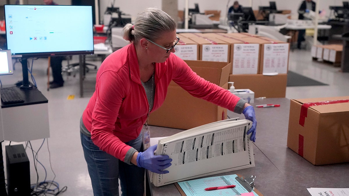 An election official holding ballots