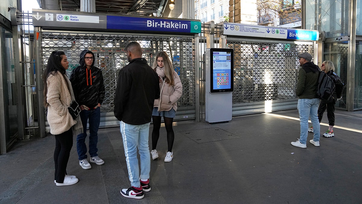 French people stand in front of closed subway