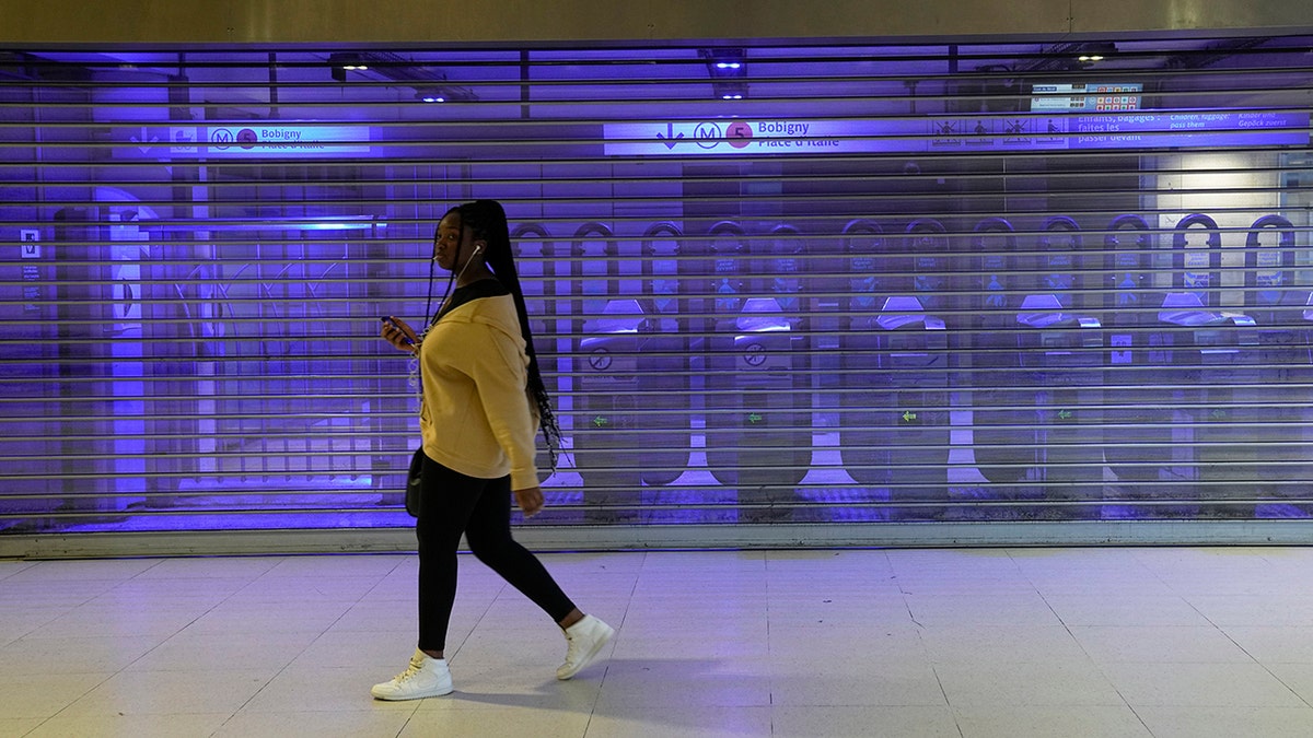 Woman walks by closed subway station