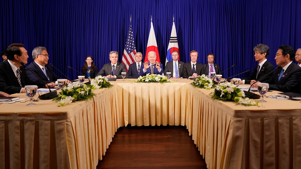 A photo of President Joe Biden at a table speaking with other officials