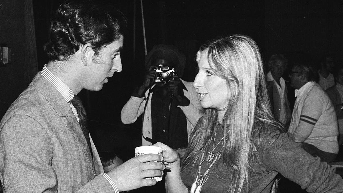 U.S. actress and singer Barbara Streisand offers a cup of coffee to Prince Charles