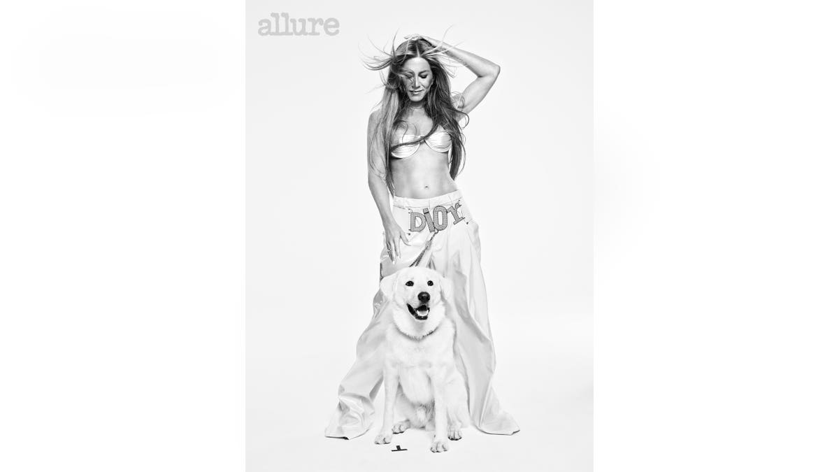 Jennifer Aniston in a crop top posing with her dog