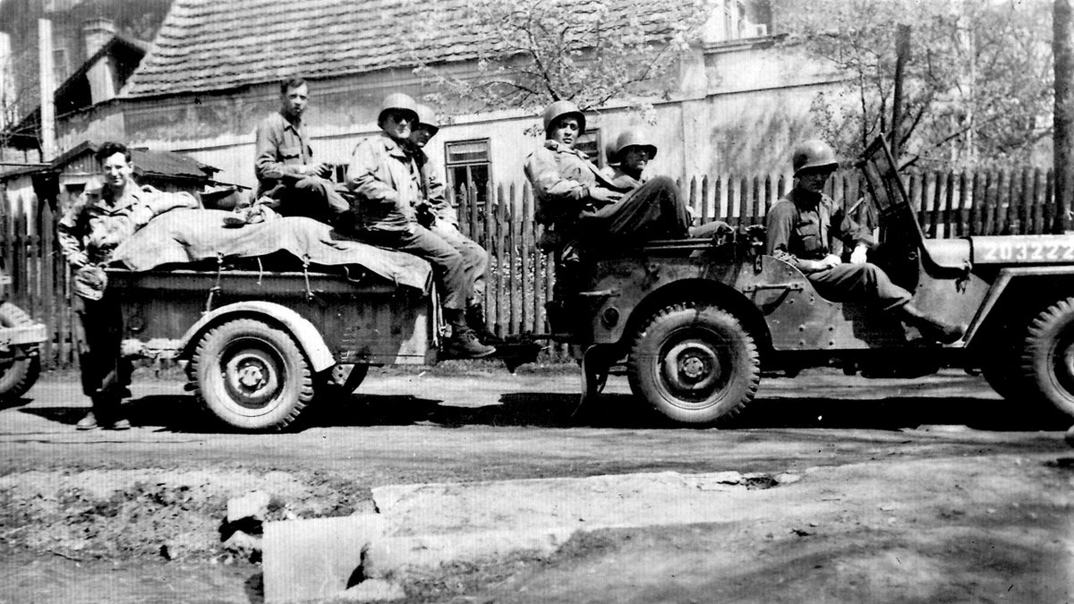 Andy Andrews and fellow troops with Jeep