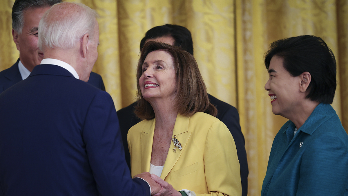 Nancy Pelosi, right, with President Biden left seen from behind