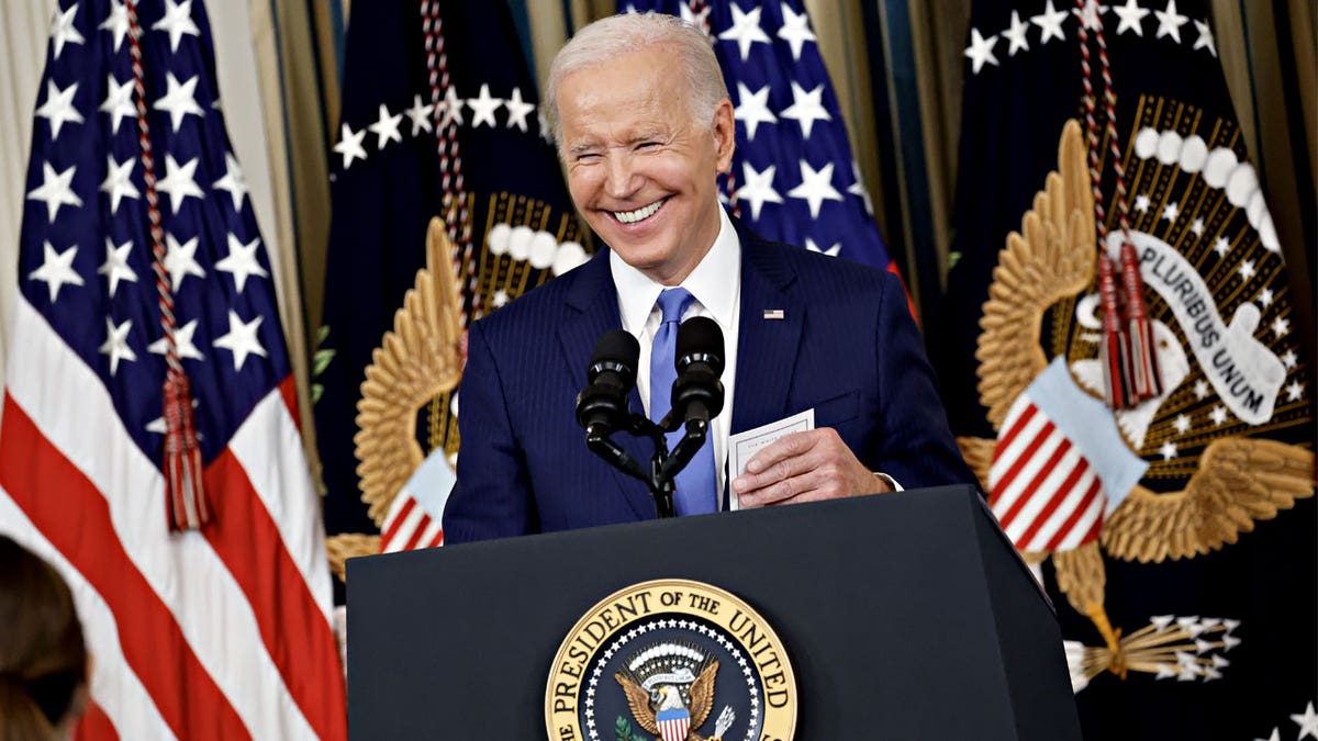 Biden smiling at podium at press conference