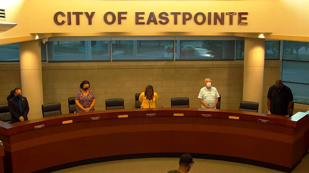 City council members standing in prayer