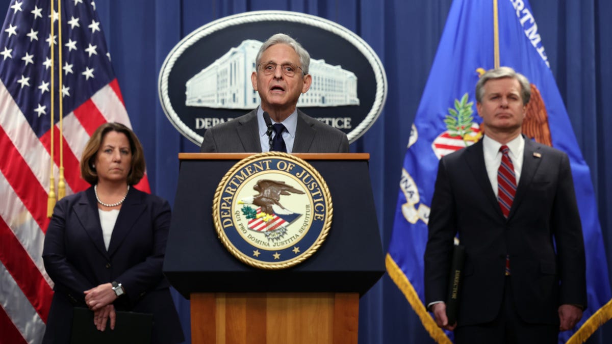 US Attorney General Merrick Garland speaks at podium alongside Deputy Attorney General Lisa Monaco and FBI Director Christopher Wray