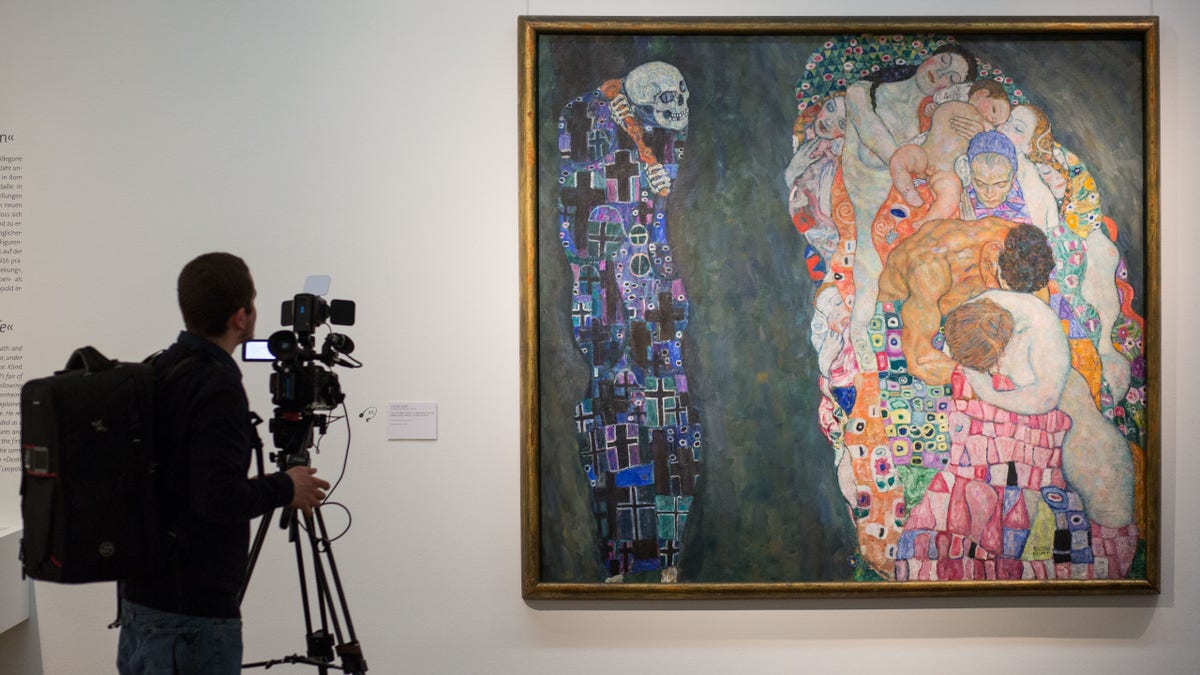 A man films "Death and Life," a painting by Gustav Klimt