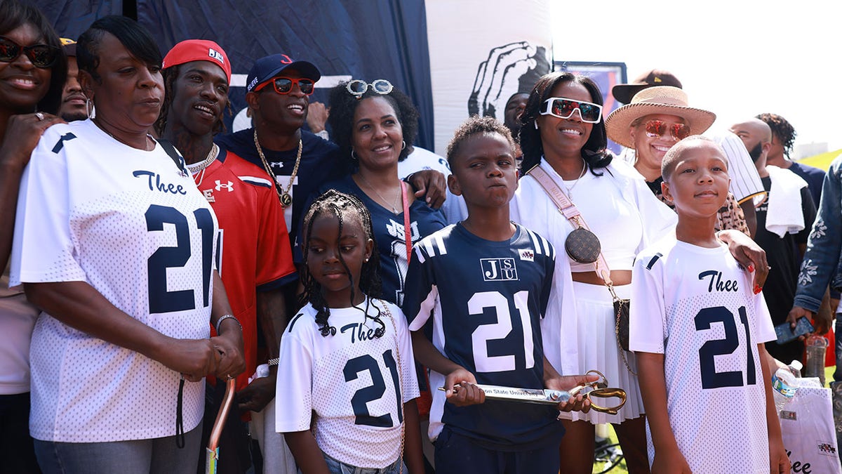 Deion Sanders takes a photo with Young Dolph's family