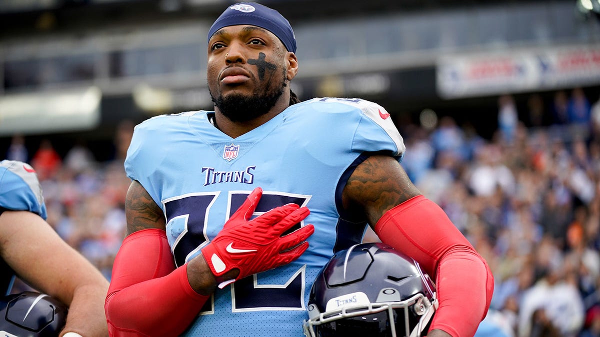 Derrick Henry listens to the anthem