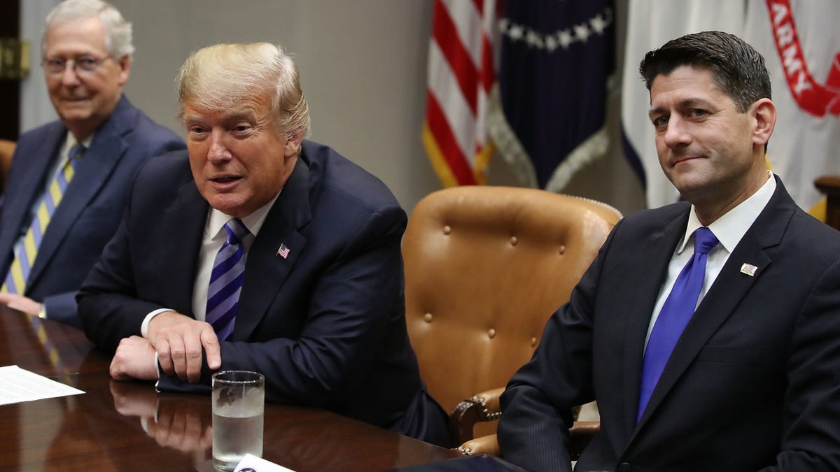 President Donald Trump sits between Senator Mitch McConnell and House Speaker Paul Ryan