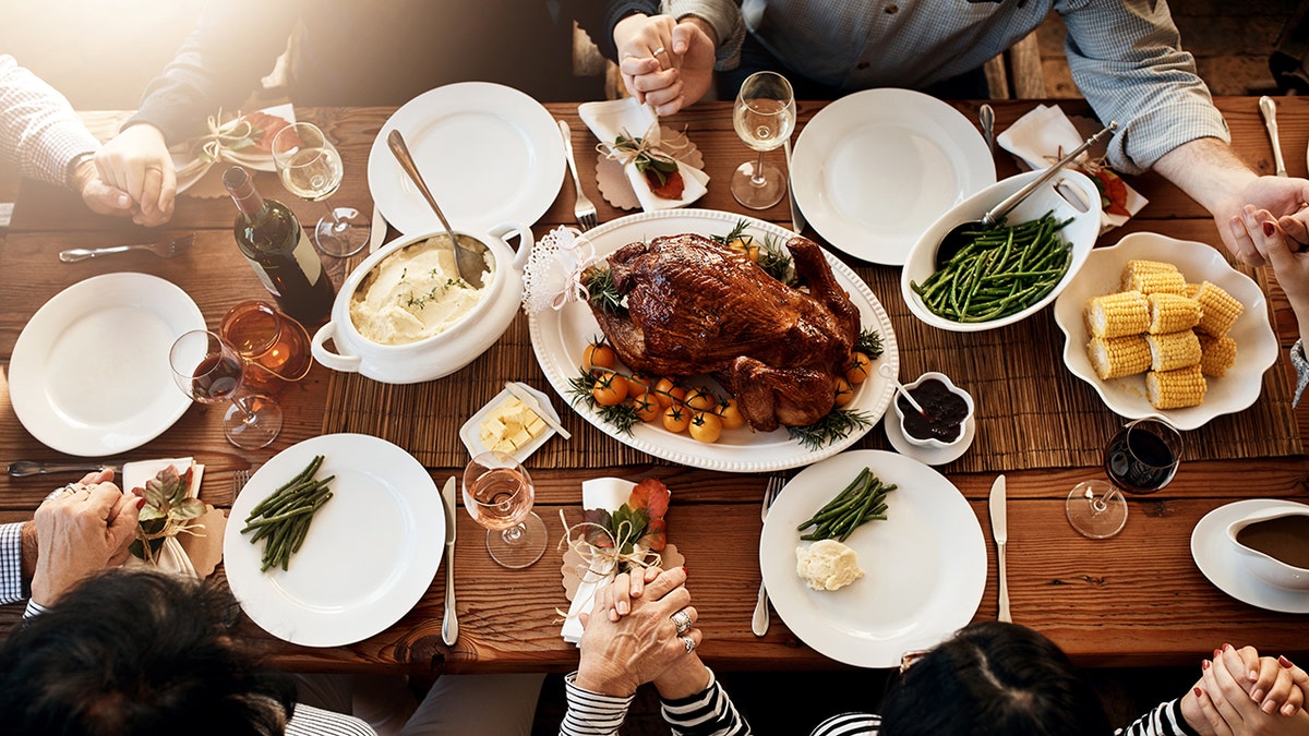 Family praying around the table for Thanksgiving