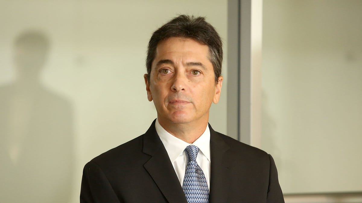 Scott Baio at a news conference in a black suit and blue tie