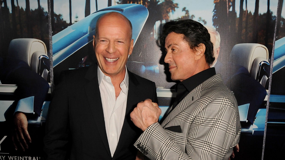 Sylvester Stallone fakes an upper cut jab at Bruce Willis on the red carpet