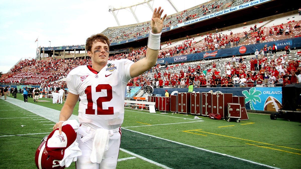 Greg McElroy waves to the crowd after a 2011 bowl game