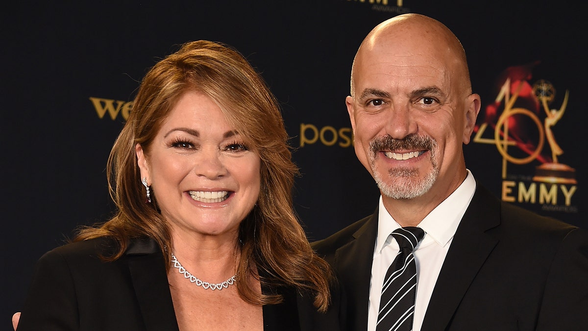 Valerie Bertinelli smiles with Tom Vitale in a striped tie at the Daytime Emmy Awards in 2019