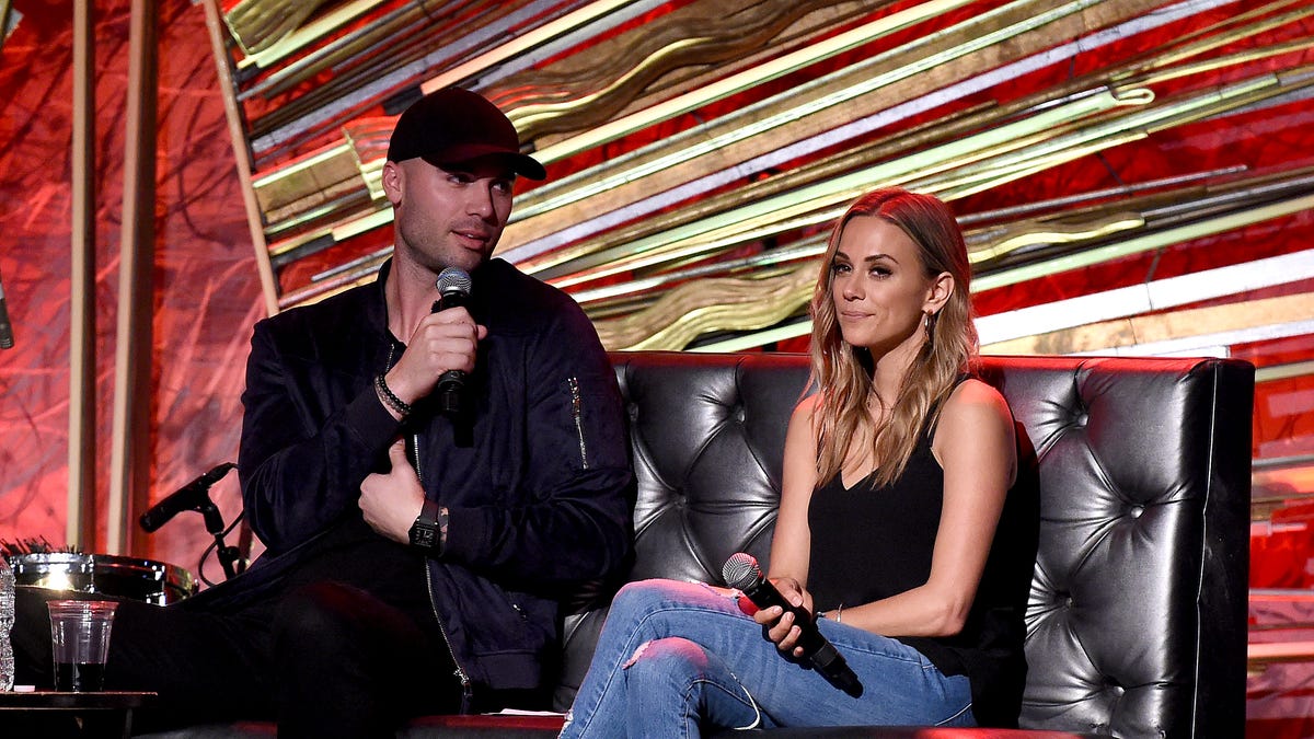 Mike Caussin and Jana Kramer speaking on stage for her podcast