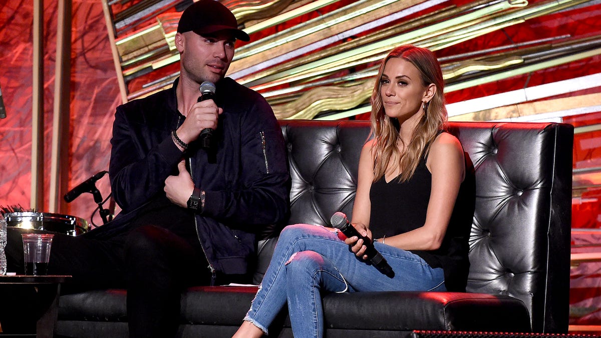 Mike Caussin and Jana Kramer speaking on stage for her podcast