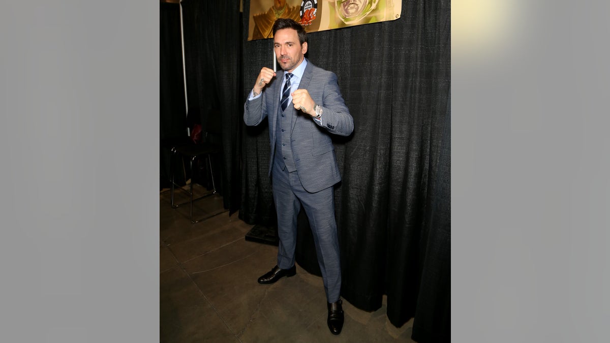 Jason David Frank in a grey suit and blue tie at a Comic Con convention