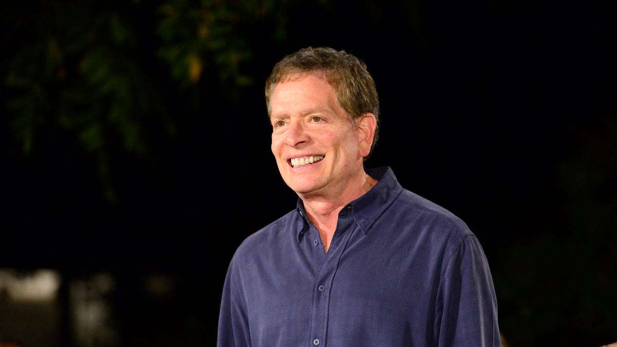 David Zucker smiles in a navy blue button down