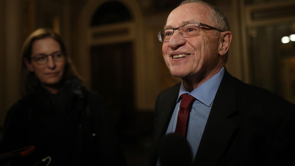 alan dershowitz smiling in media scrum