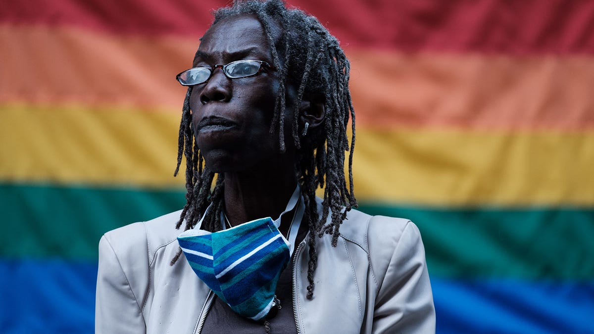 Hardesty in front of pride flag
