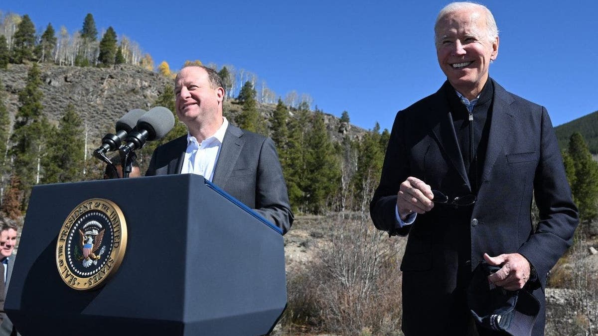 US President Joe Biden (R) smiles as Colorado Governor Jared Polis delivers remarks