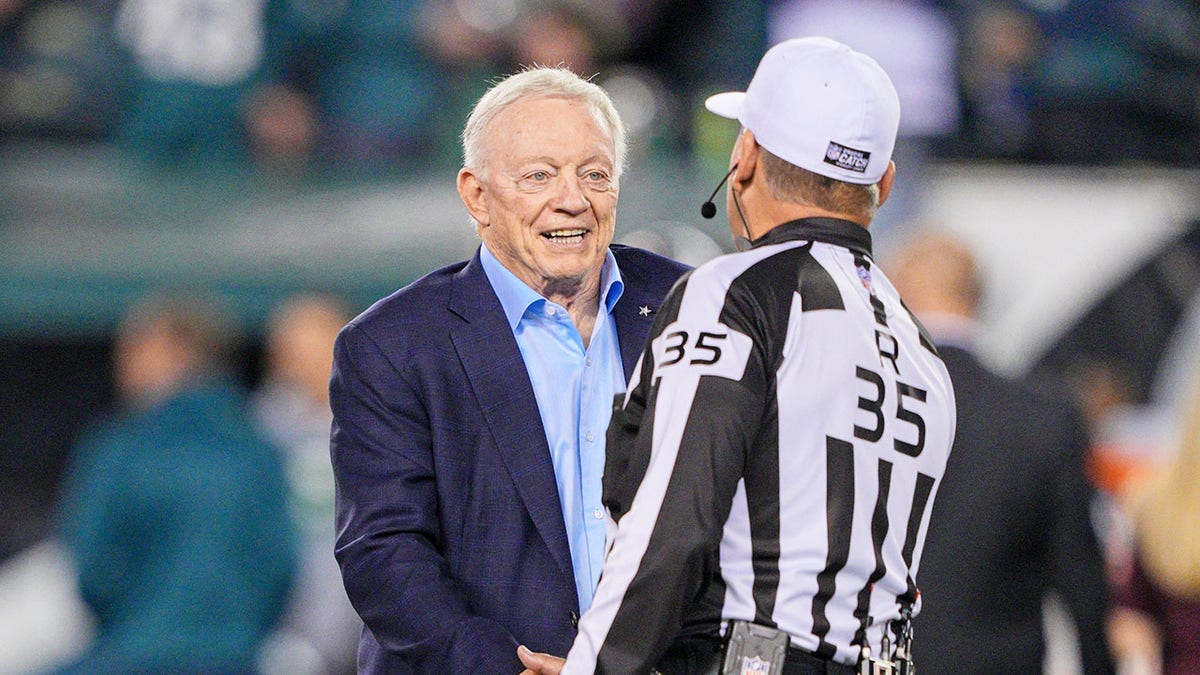 Jerry Jones shakes hands with a game official