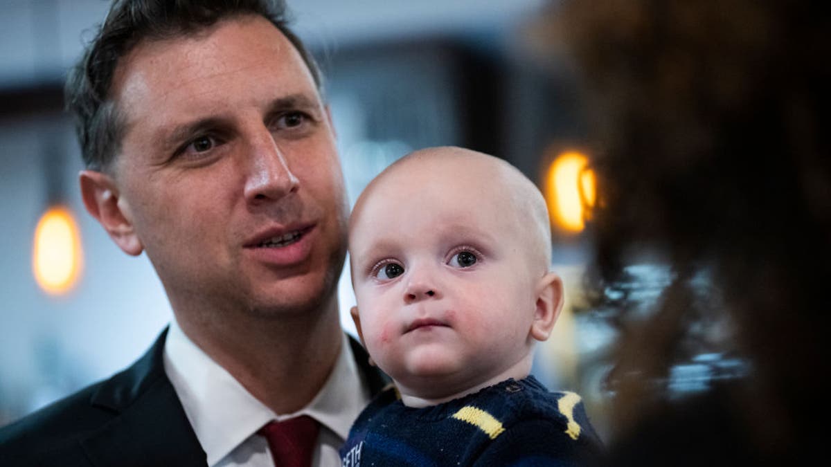 Seth Magaziner, Democratic candidate for Rhode Island's Second Congressional District, and his son Max, are seen during a campaign event with first lady Jill Biden at the Santa Maria Di Prata Society in Cranston, Rhode Island, on Wednesday, Oct. 26, 2022. 