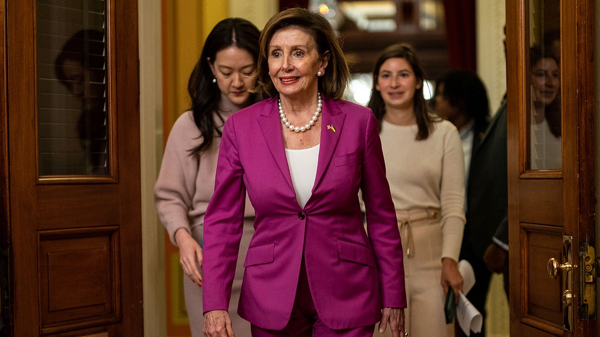 Pelosi walking with her staff