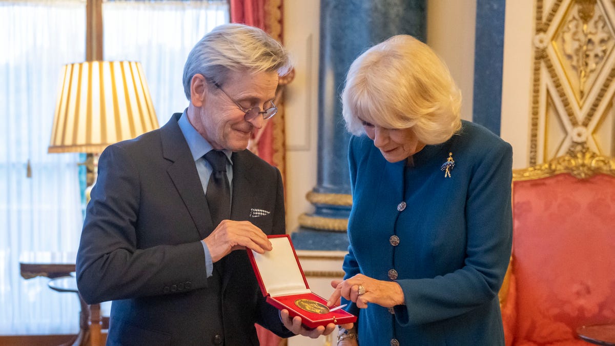 The Queen Consort Camilla looks down at the medal she presented to dancer Mikhail Baryshnikov