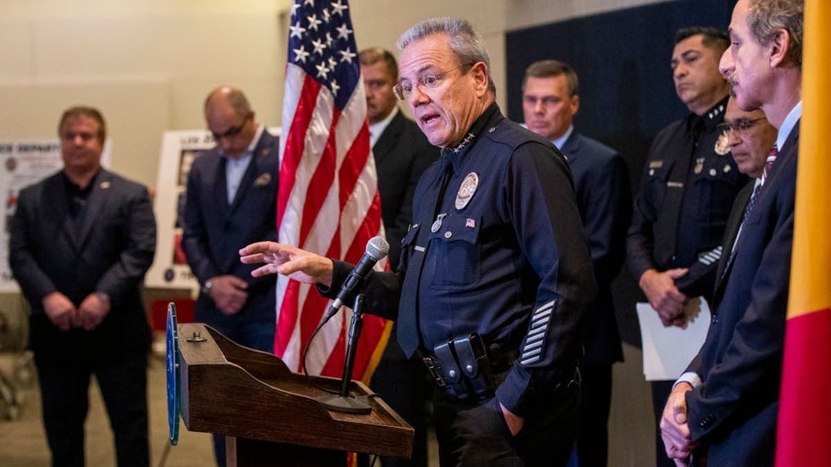 LAPD Chief Moore speaks into microphone during press conference