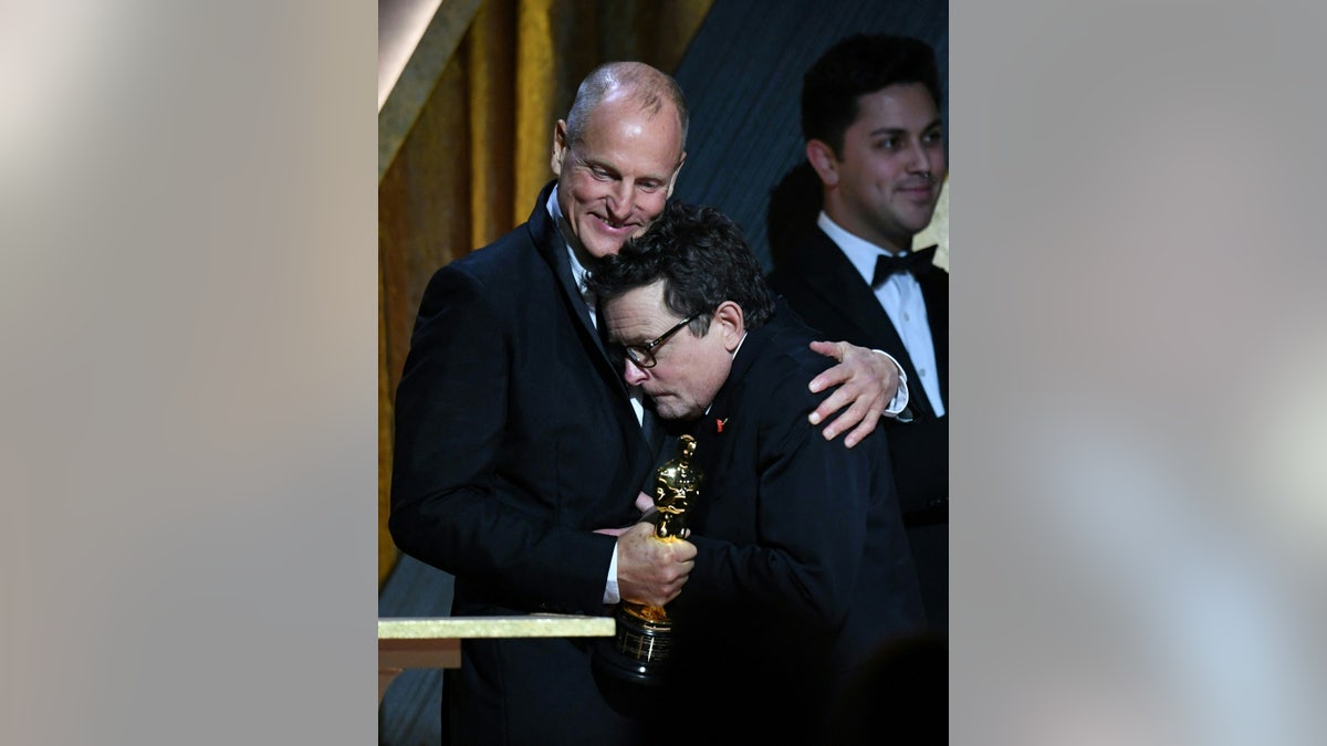 Woody Harrelson hugs his friend Michael J. Fox as he presents him with an honorary Oscar