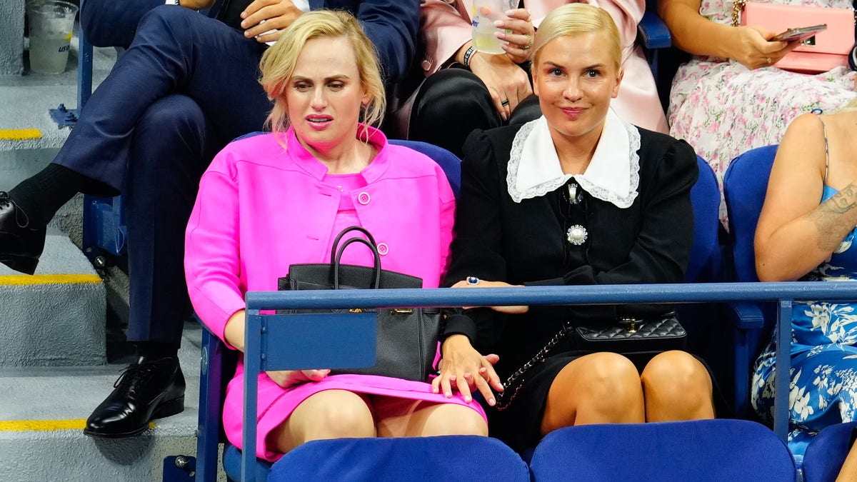 Rebel Wilson and Ramona Agruma are spectators at the US open in bright pink and black outfits