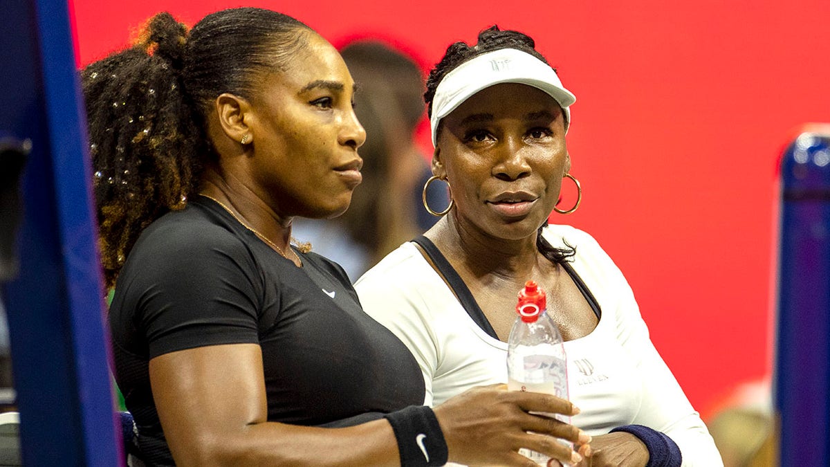 Serena and Venus Williams talk during their US Open doubles match