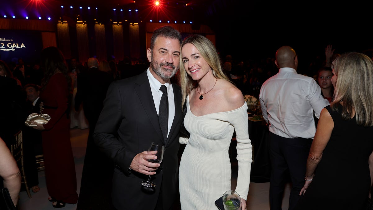 Jimmy Kimmel in a black suit alongside his wife Molly in a cream off-the-shoulder dress