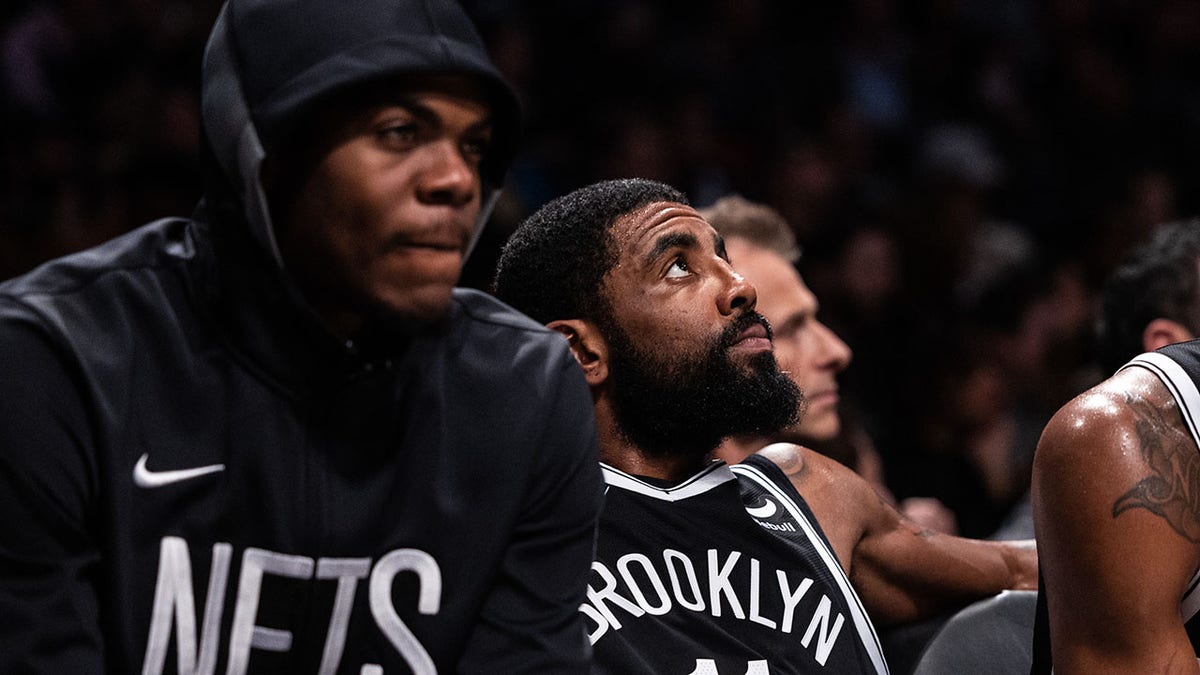 Kyrie Irving looks on from the Nets bench